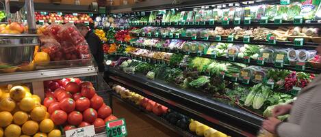 A grocery store with fresh produce and packaged goods on shelves.