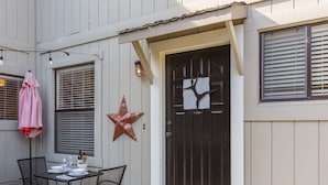 A house with a dark brown front door, a star decoration, and a table with chairs outside.