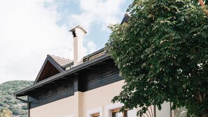Un edificio de dos plantas con balcón, mesas al aire libre y un letrero de restaurante.