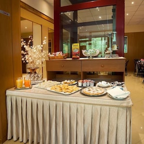 Una mesa de buffet con diferentes platillos y una cesta de frutas.