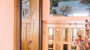 Una puerta de madera con paneles de vidrio y vistas a un lago con árboles y montañas al fondo.