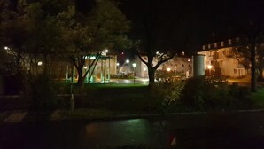 A nighttime outdoor area with a gazebo, trees, and a building in the background. - Lakeside Smoker Apartment FDH (Friedrichshafen)