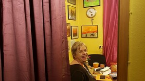 A room with a yellow wall, a clock, and a table with various items. - Lakeside Smoker Apartment FDH (Friedrichshafen)