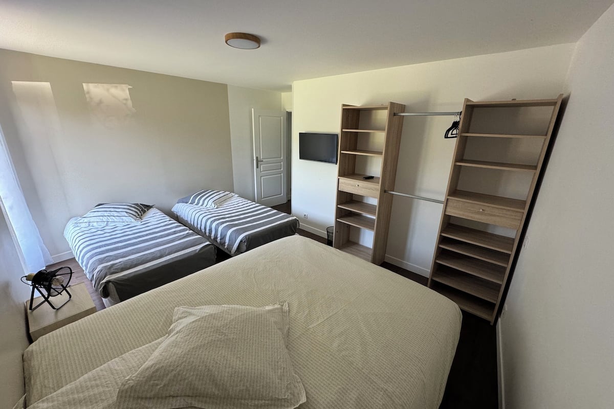 Ein Schlafzimmer mit zwei Betten, einem Kleiderschrank und einem Schreibtisch.