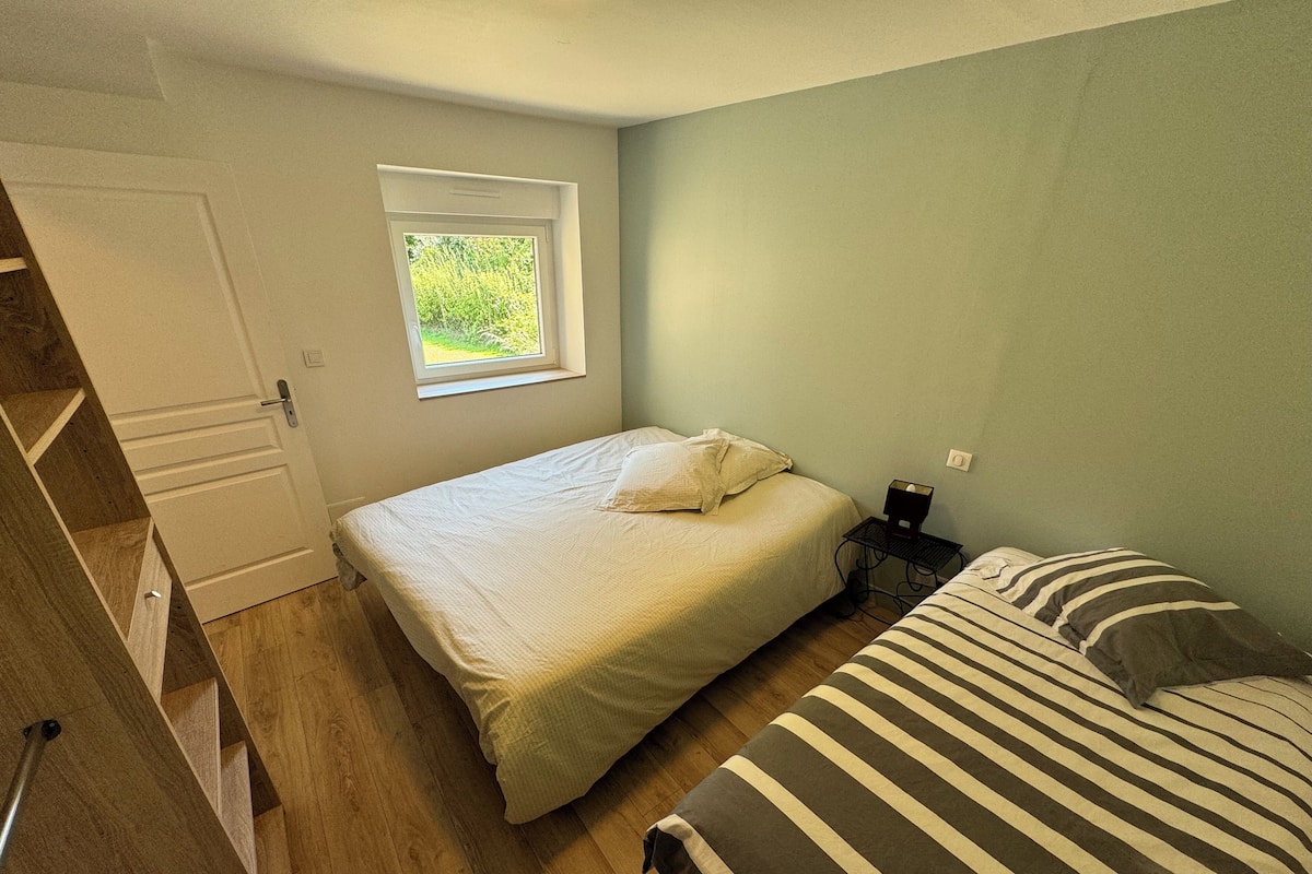 Ein Schlafzimmer mit Bett, Nachttisch, Fenster und Kleiderschrank.