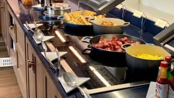 A buffet setup with various food items and utensils.