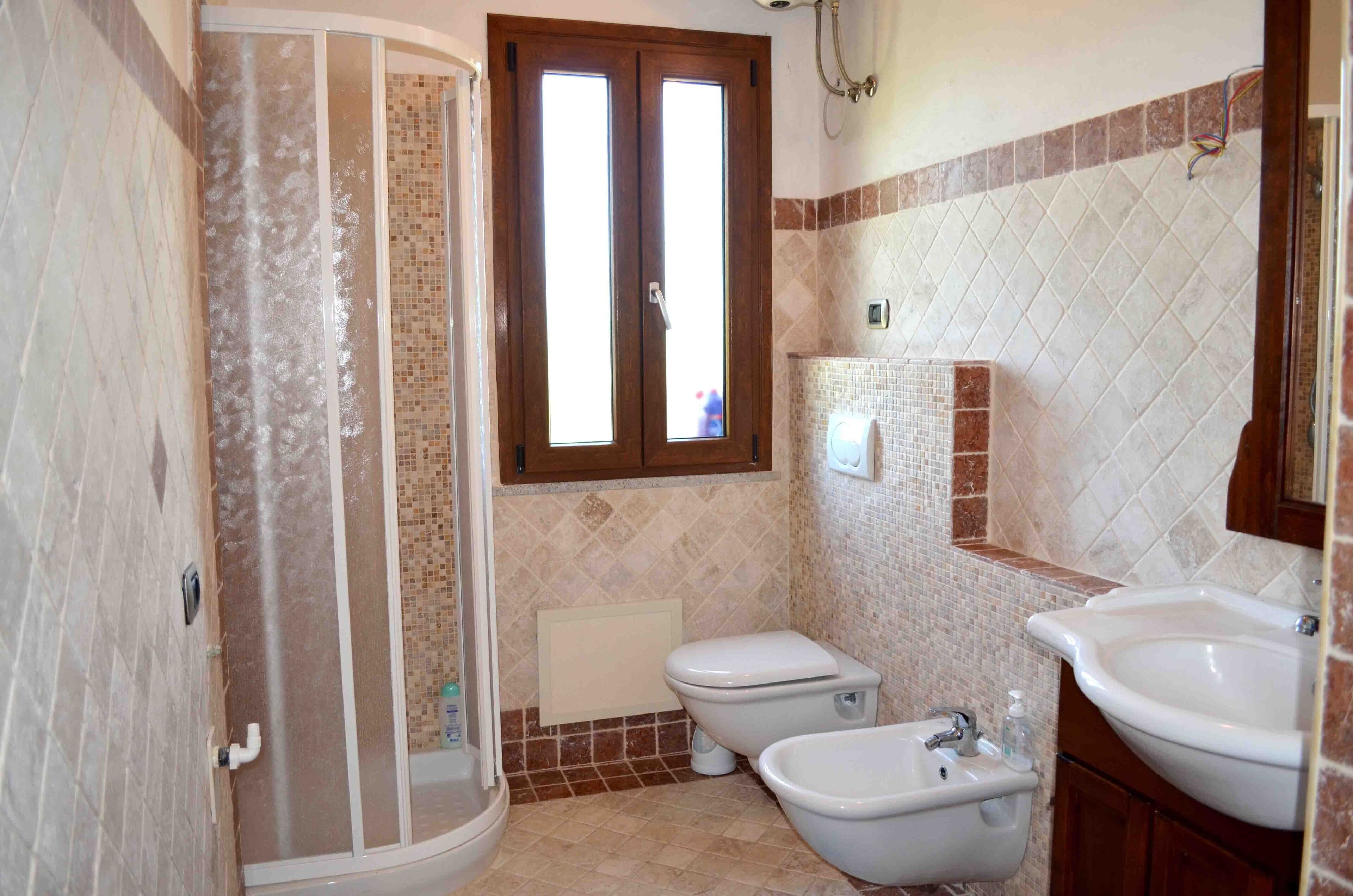 Ein Badezimmer mit Dusche, Toilette, Bidet und Waschbecken.