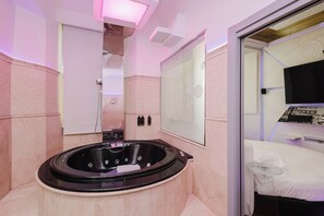 Une salle de bain moderne avec une baignoire sur pieds, un grand miroir et un espace douche séparé.