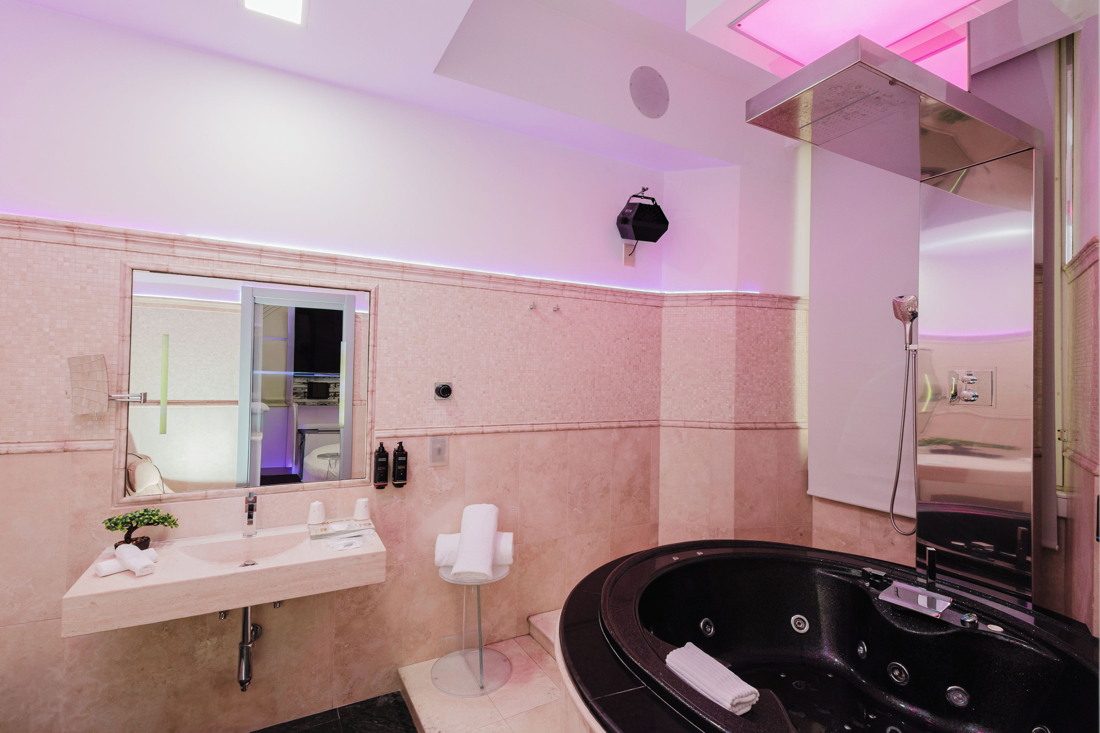 A modern bathroom with a large mirror, a sink, a bathtub, and a shower area.