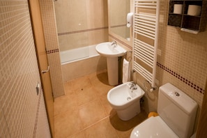 Een bad, een haardroger, badjassen, een bidet