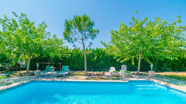 A rectangular swimming pool with clear blue water, surrounded by a stone deck. There are lounge chairs and a small table with a lamp. - SON PUJOL - Villa with private pool in MONTUÏRI. Free WiFi (Montuïri)