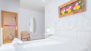 A hotel room with a bed, a chair, a small table, a mirror, and a painting on the wall. - SON PUJOL - Villa with private pool in MONTUÏRI. Free WiFi (Montuïri)