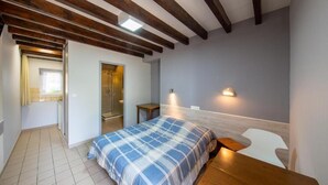 A bedroom with a bed, a wooden desk, a chair, a mirror, and a small table. - Auberge du Tranchoir (Nevoy)