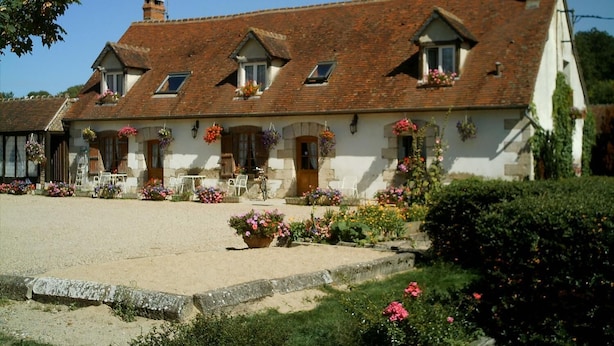 A traditional stone building with a tiled roof, multiple windows, and flower boxes. - Auberge du Tranchoir (Nevoy)