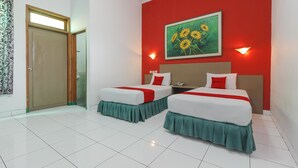A hotel room with two beds, red walls, a painting of sunflowers, and a green curtain. - RedDoorz Plus near Alun Alun Kejaksan Cirebon (North Cirebon)
