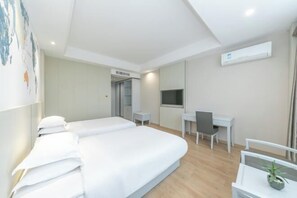 A hotel room with a large bed, a desk, a chair, and a television. - Zhoushan New Town Kaiyuan Yiju Hotel (Zhoushan)