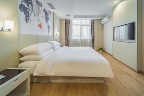 A modern hotel room with a large bed, a desk, a world map on the wall, and a TV mounted on the wall. - Zhoushan New Town Kaiyuan Yiju Hotel (Zhoushan)