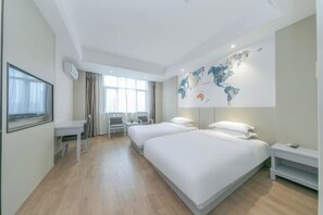 Ein Hotelzimmer mit zwei Betten, einem Schreibtisch, einem Sessel, einem Fernseher und einer Weltkarte an der Wand.