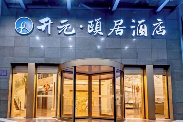 Ein Hotel Eingang mit einer Drehtür und einem Schild mit chinesischen Schriftzeichen.