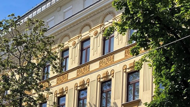 A multi-story building with classical architectural features, including ornate cornices and symmetrical windows.
