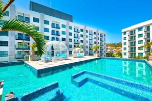 Um hotel moderno com piscina infinita no terraço, água azul cristalina e arquitetura contemporânea.