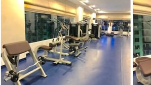 Een sportschool met trainingsapparatuur en een blauwe vloer.