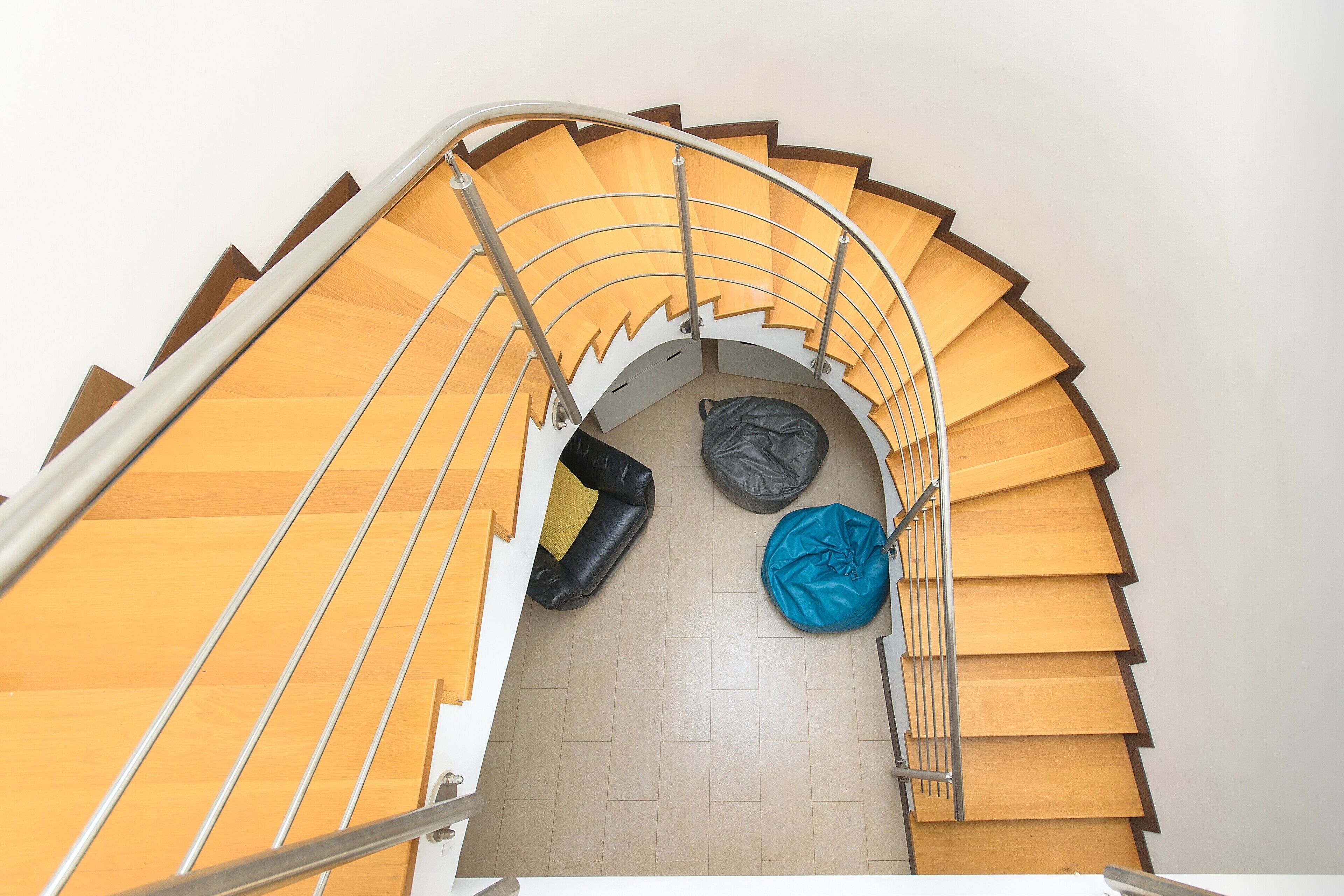 A spiral staircase with a beige floor and a metal railing.