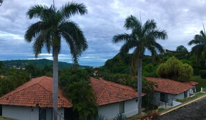 Ein Resort mit mehreren Gebäuden und roten Ziegeldächern, umgeben von üppiger Vegetation und Palmen.