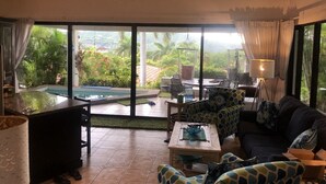 A spacious living area with a pool, outdoor seating, and large windows offering a view of the surrounding greenery. - Casa Da'Vida In Playa Hermosa, Guanacaste, Costa Rica (Playa Hermosa)