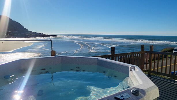 Een jacuzzi met uitzicht op de oceaan en een strand.