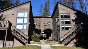A modern two-story house with a central entrance and a staircase leading to the main door.