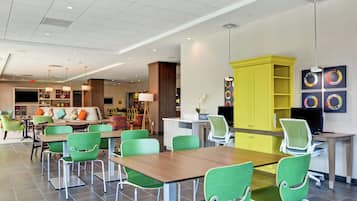 Um hall de hotel moderno com cadeiras verdes, um balcão de recepção de madeira e um armário amarelo.