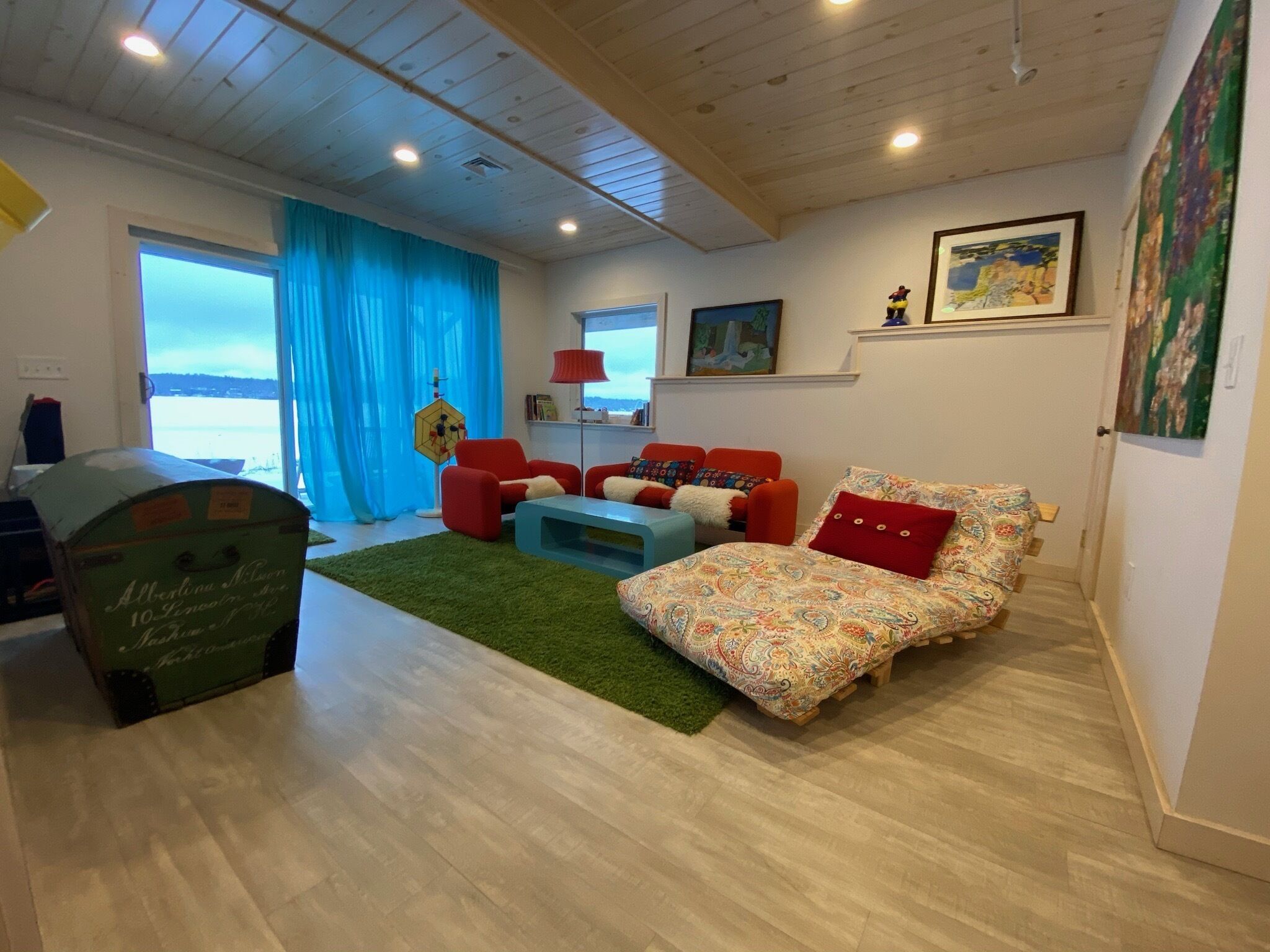 Un salon confortable avec un canapé, des fauteuils, une table basse et une vue sur l’extérieur.