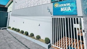 Ein modernes Gebäude mit einem Schild, das 'RESIDENCIAL MAIA' zeigt, und einem verschlossenen Eingang.