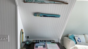 A room with a desk, a whiteboard, and a couch. - Riverfront A-Frame w/ Dock, Kayaks, Putt-Putt & Shuffleboard (Oscoda Twp)