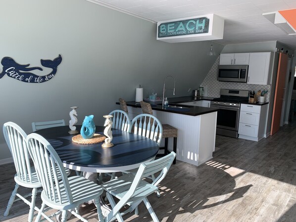 A modern kitchen with white cabinets, a built-in microwave, and a stainless steel stove. - Riverfront A-Frame w/ Dock, Kayaks, Putt-Putt & Shuffleboard (Oscoda Twp)