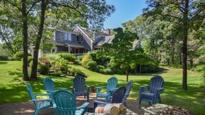 A house with a porch, surrounded by a well-maintained lawn and trees.