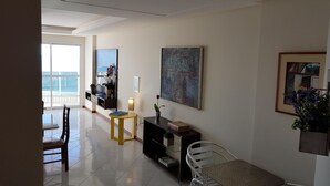 A modern living room with a large window, a dining area, and a view of the ocean. - INCREADIBLE VIEW! UNFORGETABLE PLACE! YOU MUST TRY IT! (Guarapari)