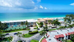 A coastal hotel with multiple buildings, a tennis court, and a parking lot. - Runaway Bay 135 - Beach, Pool, gym and bay (Bradenton Beach)