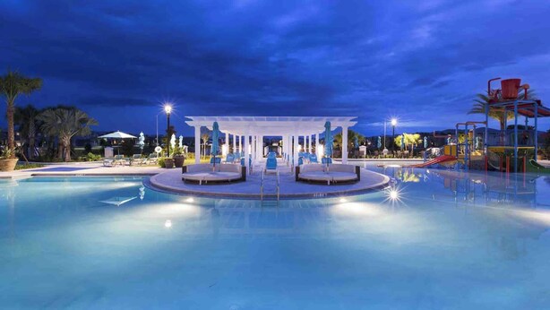 A swimming pool with a covered seating area and a children's play structure. - Kids Bedrooms | Games | Screened Pool | Near Attractions (Kissimmee)