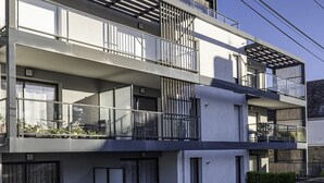 A modern multi-story building with balconies, large windows, and a stone facade. - L'Ilôt Bateau apartment very close to the corniche for 2 people (Concarneau)