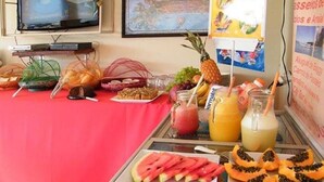 A buffet table with various fruits, juices, and snacks. - Pousada Luzes de Geribá (Búzios)