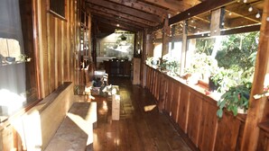 A wooden interior with benches, potted plants, and a kitchen area. - Santa Ana City Views Breathtaking Chalet (Santa Ana)