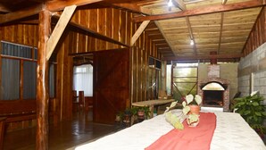 A rustic wooden interior with a fireplace, wooden beams, and a bed with a red blanket. - Santa Ana City Views Breathtaking Chalet (Santa Ana)