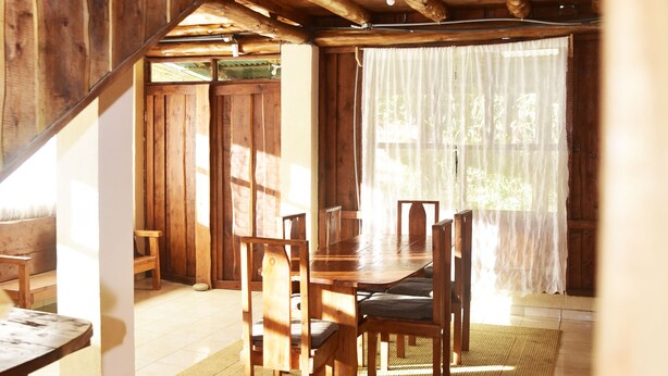 A wooden interior with a dining area, a staircase, and a view of the outdoors. - Santa Ana City Views Breathtaking Chalet (Santa Ana)
