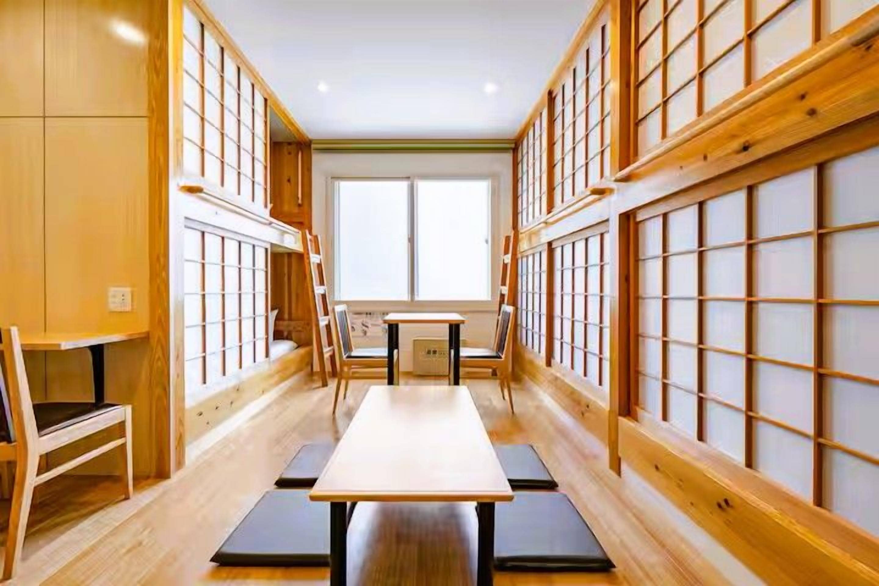 A traditional Japanese room with tatami flooring, a low table, and sliding doors.