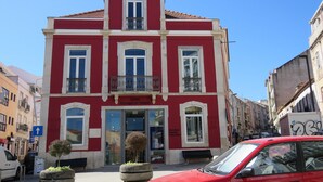 A red building with a balcony, a door, and a window. - TEJO HOUSE RIVER Lisbon (Cacilhas) (Almada)