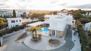 Une villa moderne dotée d’une piscine, d’un patio couvert et d’un jardin aménagé.