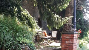 A stone pathway leading to a brick structure with a sign, surrounded by greenery and a stone wall. - Stone Rustico with Jacuzzi, Infrared Sauna Escluiva   (Boveglio)