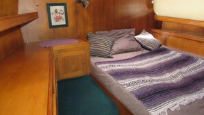 Ein gemütliches Blockhaus mit Bett, Tisch und Wandlampe.